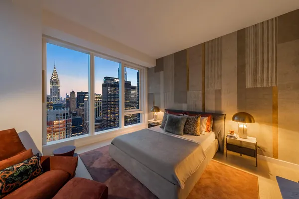 a bedroom with furniture and a large window