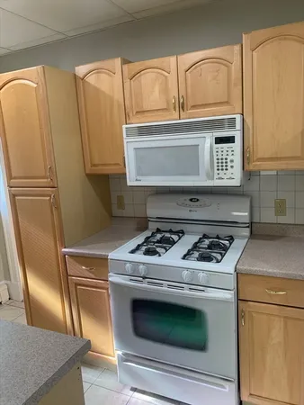 a stove top oven sitting inside of a kitchen