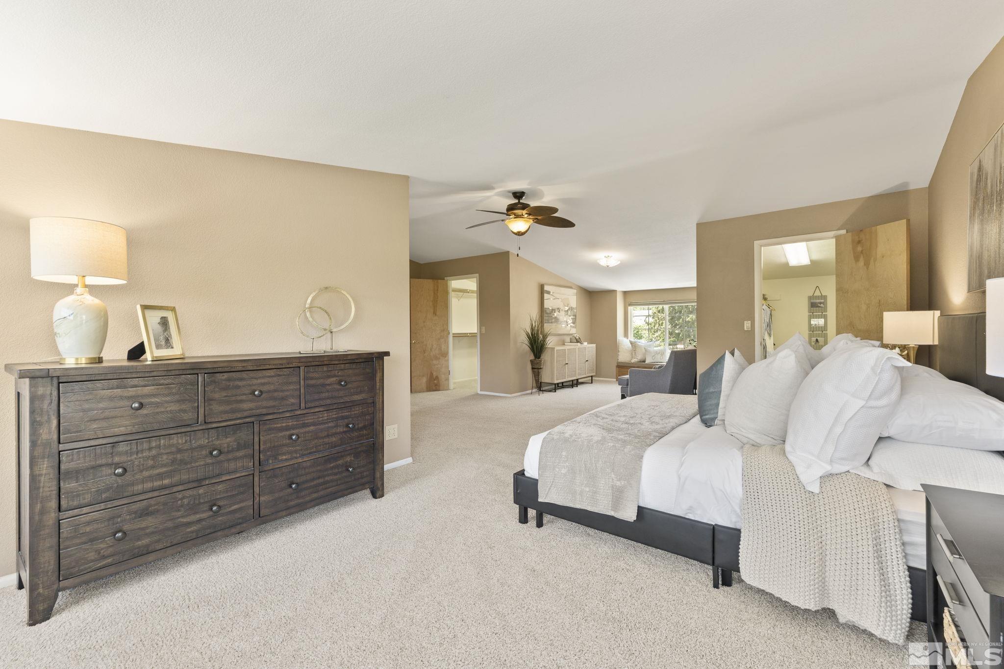 2250 Barnes Boulevard Reno, NV 89509 - Photo 12 of 40 a spacious bedroom with a bed a lamp and a large mirror