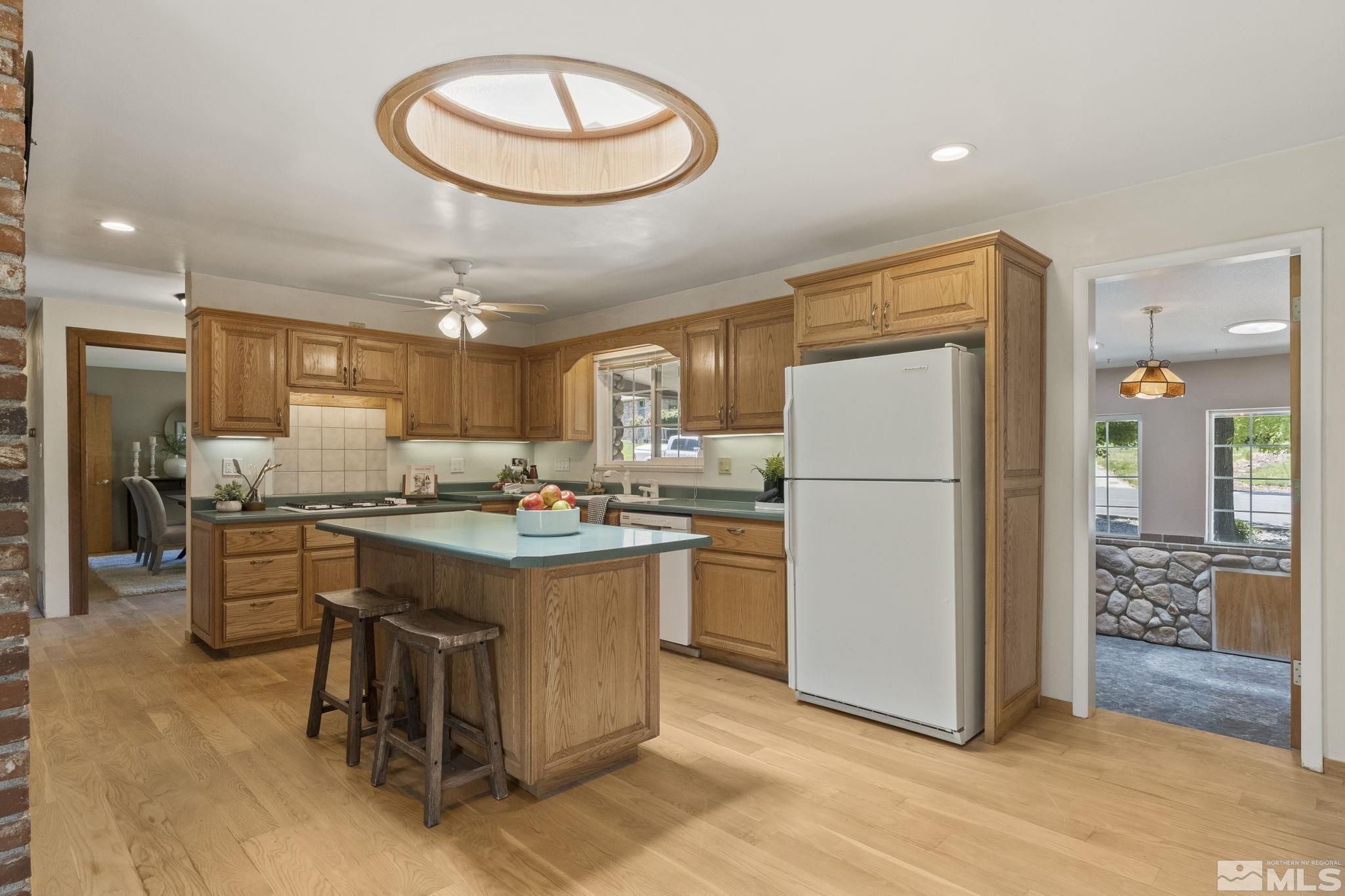 2250 Barnes Boulevard Reno, NV 89509 - Photo 6 of 40 a kitchen with stainless steel appliances granite countertop a refrigerator a stove a sink a dining table and chairs