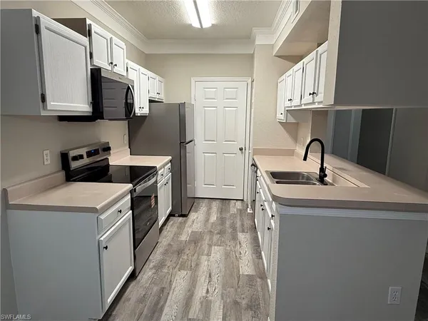 a kitchen with stainless steel appliances a sink stove and microwave