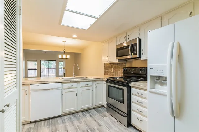a kitchen with stainless steel appliances a stove sink microwave and refrigerator