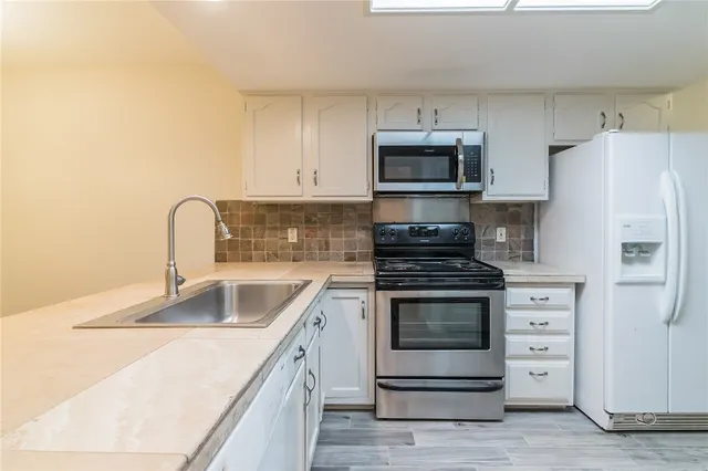 a kitchen with stainless steel appliances granite countertop a stove microwave and refrigerator