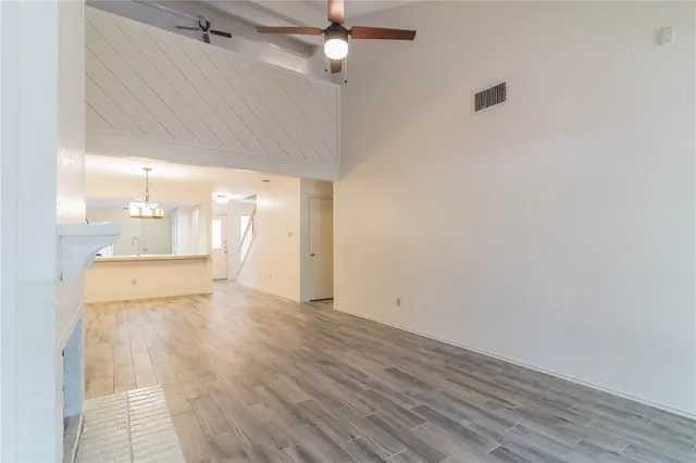 a view of a room with wooden floor and a ceiling fan