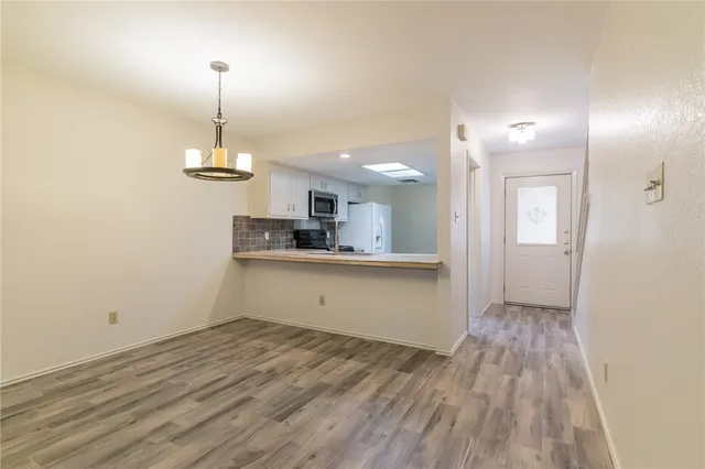 a view of a kitchen with a sink and dishwasher wooden floor