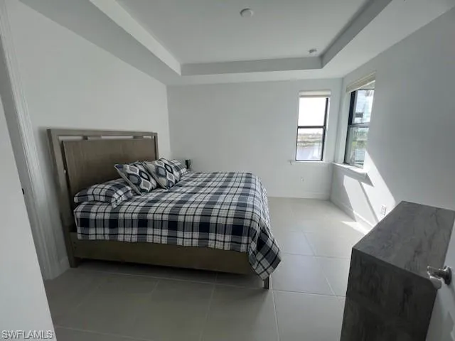 a bedroom with a bed a mirror and a window