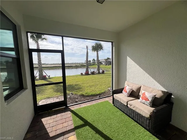 a living room with a rug floor to ceiling window and a flat screen tv