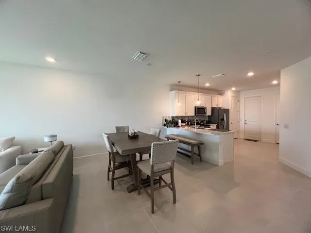 a kitchen with a dining table chairs and view living room