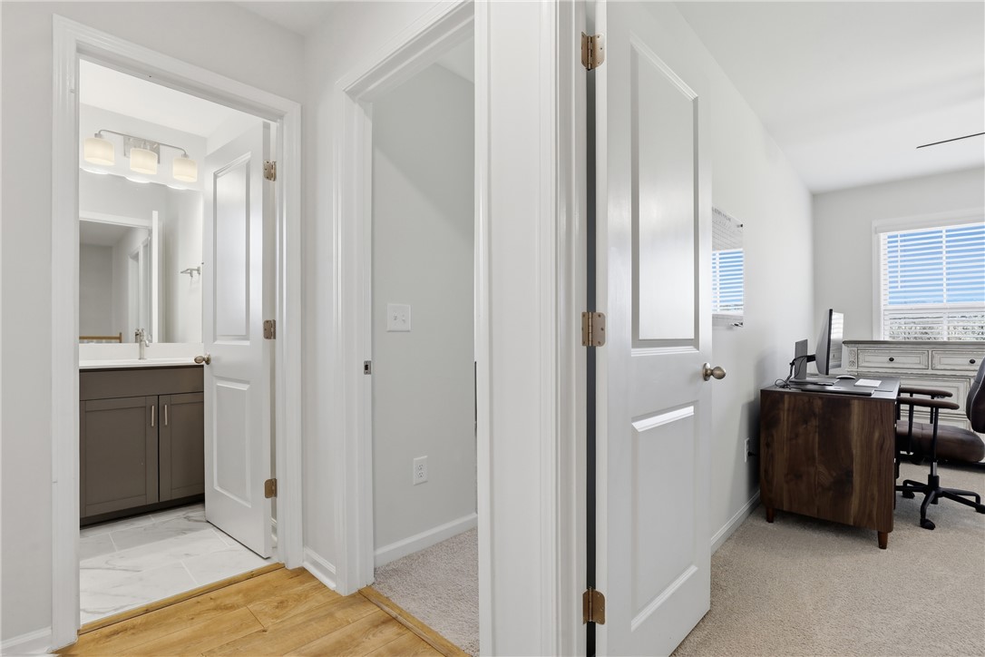 349 Stirrup Court Greer, SC 29651 - Photo 15 of 27 This interior hallway offers convenient access to a modern bathroom and a functional office space.