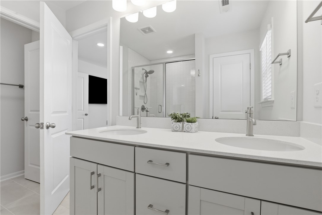 349 Stirrup Court Greer, SC 29651 - Photo 16 of 27 This bathroom features a double vanity with ample counter space and a modern shower.