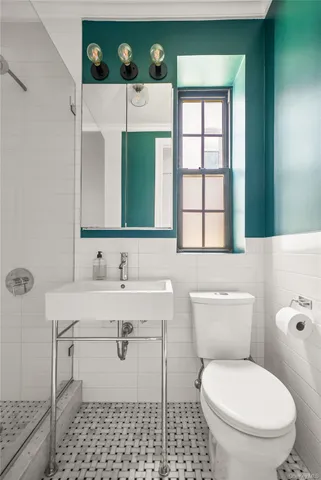 a bathroom with a sink a toilet and mirror