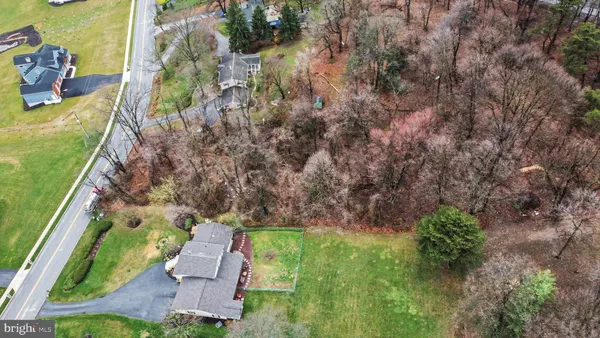 an aerial view of a house with a garden and lake view