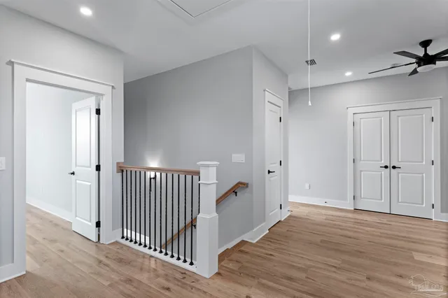 a view of a hallway with wooden floor and closet area