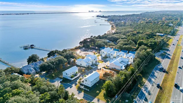 an aerial view of a house with a lot of trees houses lake and ocean view