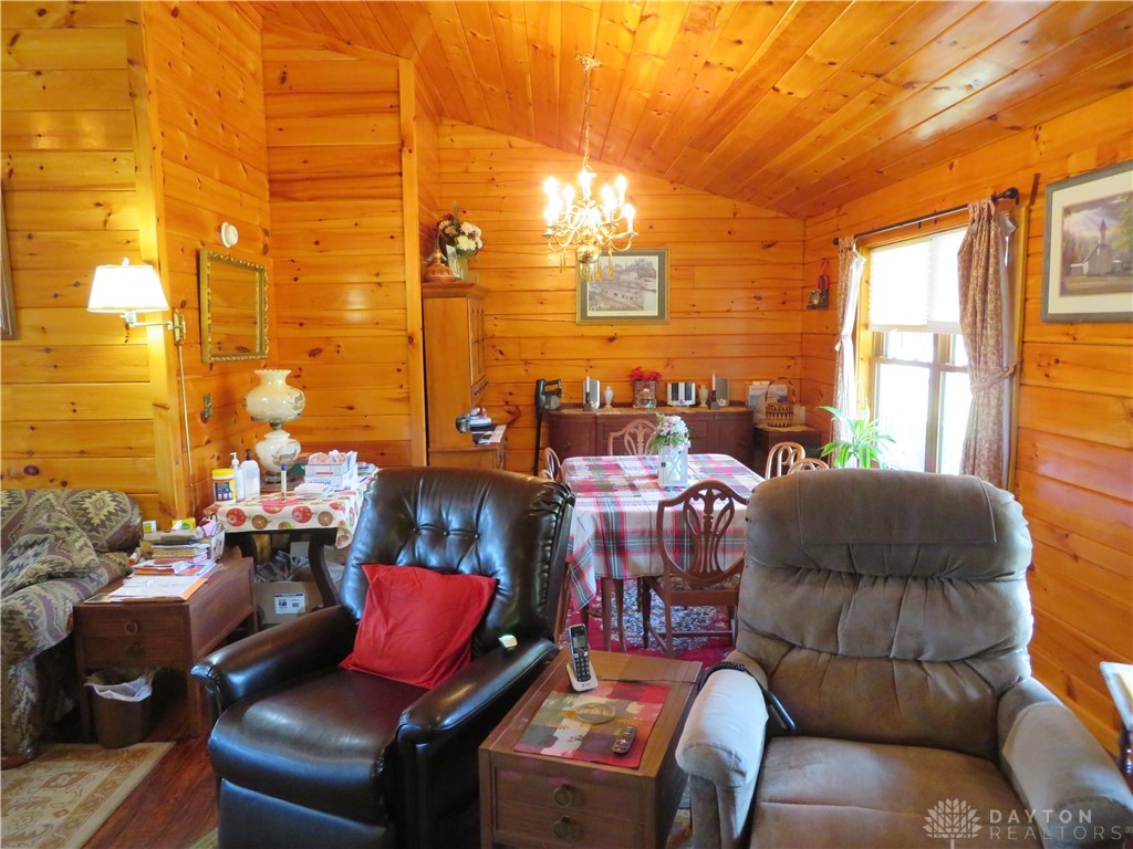748 Inlow Avenue Peebles, OH 45660 - Photo 11 of 61 This living and dining area features rich wood-paneled walls and ceilings, creating a warm, inviting atmosphere.