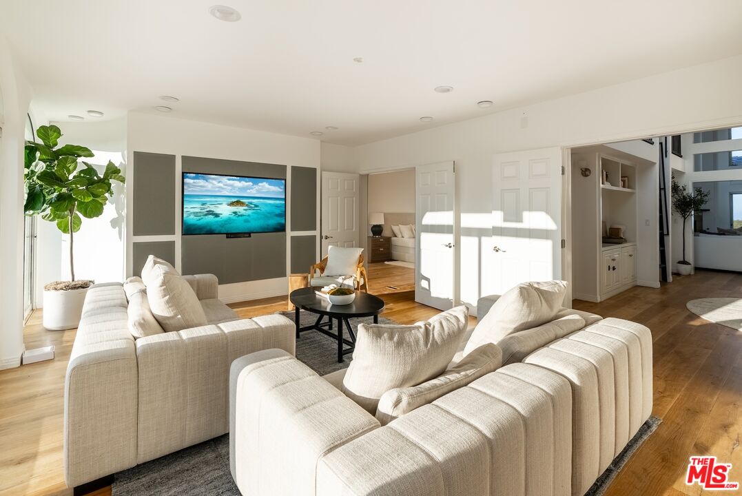 21965 Saddle Peak Road Topanga, CA 90290 - Photo 12 of 56 a living room with furniture a flat screen tv and a large window