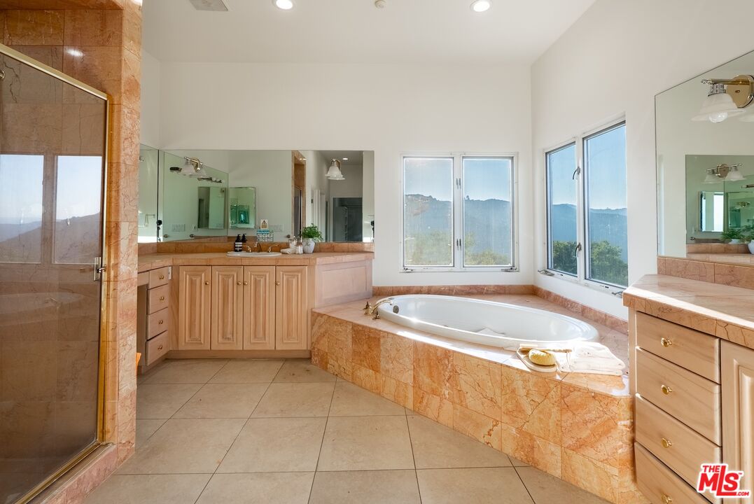 21965 Saddle Peak Road Topanga, CA 90290 - Photo 23 of 56 a spacious bathroom with a tub sink and mirror