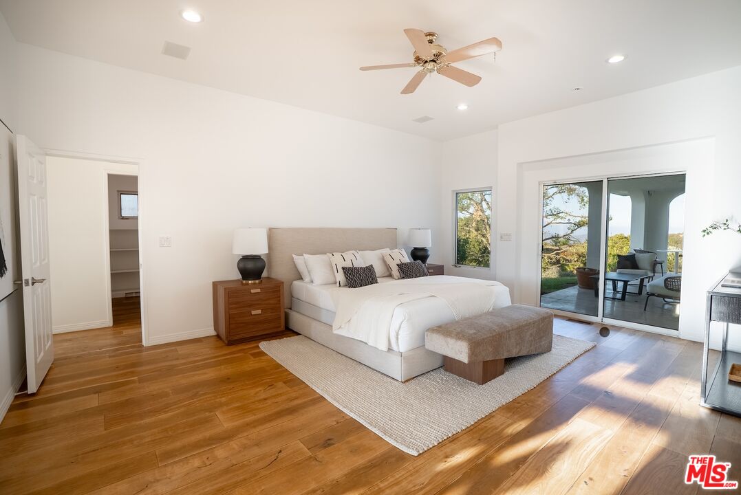 21965 Saddle Peak Road Topanga, CA 90290 - Photo 29 of 56 a spacious bedroom with a large bed and a chandelier