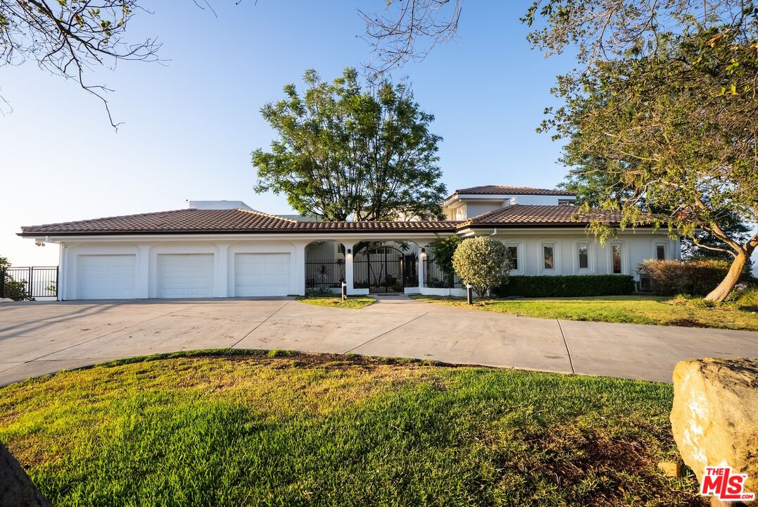 21965 Saddle Peak Road Topanga, CA 90290 - Photo 44 of 56 a front view of a house with a yard and garage