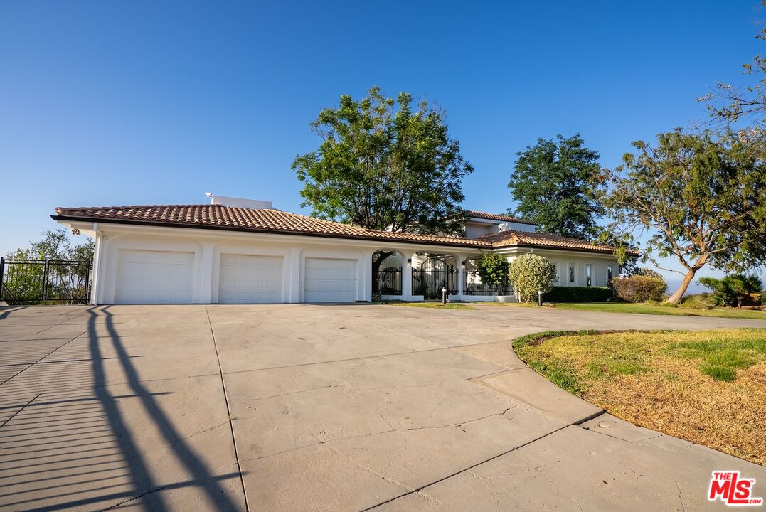 21965 Saddle Peak Road Topanga, CA 90290 - Photo 45 of 56 a front view of a house with a yard and trees