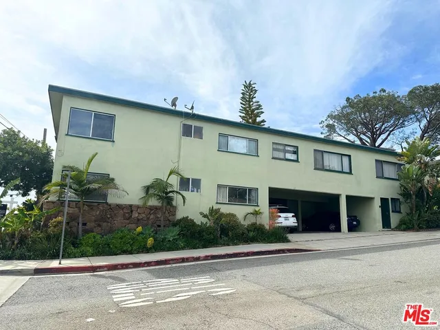 a front view of a house with plants and garage