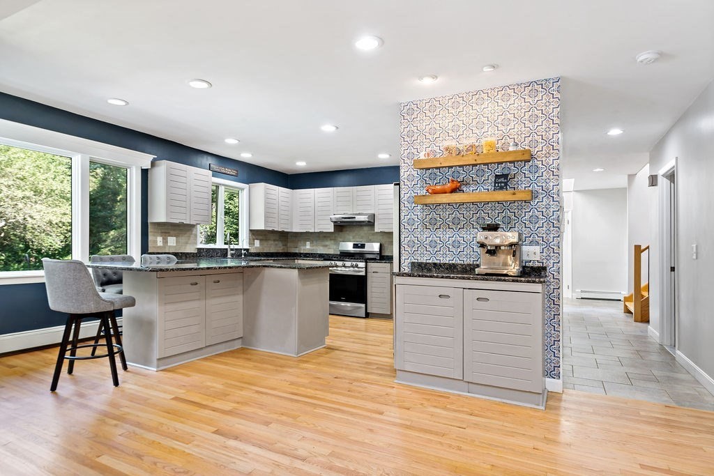 25 Hickory Ridge Road Rehoboth, MA 02769 - Photo 2 of 42 a kitchen with stainless steel appliances granite countertop a stove top oven a sink and a dining table with wooden floor