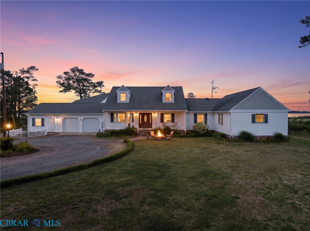 9093 Stump Point Road Hayes, VA 23072 - Photo 1 of 40 White exterior with dark shutters, featuring a three-car garage and a circular driveway