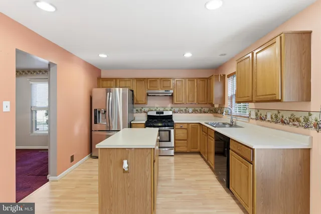 a large kitchen with stainless steel appliances lots of counter space and wooden floor