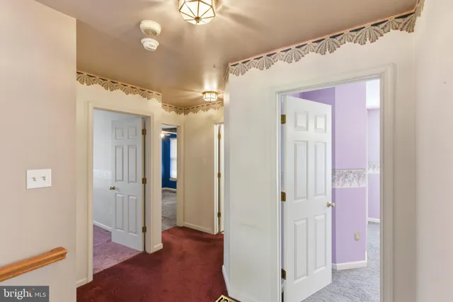a view of an empty room with window and a ceiling fan