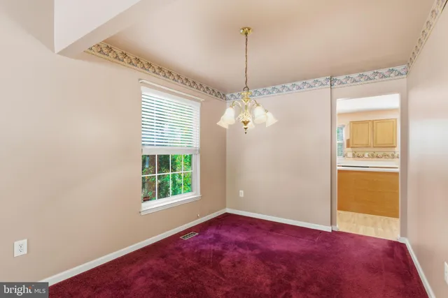 a view of an empty room with window and cabinet