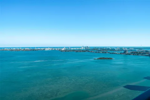 a large bedroom with a bed and glass window