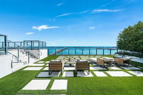 a view of swimming pool with seating area and lake view