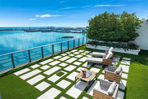 a large white kitchen with a large window and stainless steel appliances