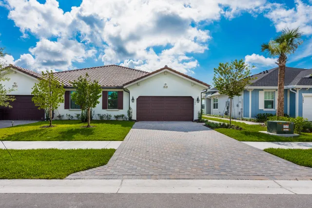 a front view of a house with a yard and garage