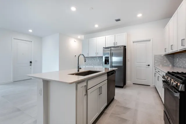 a kitchen with stainless steel appliances granite countertop a sink stove and refrigerator