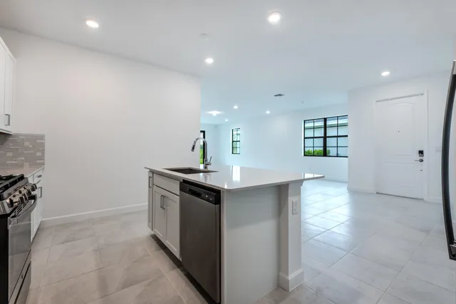 a kitchen with stainless steel appliances granite countertop a sink and a stove top oven