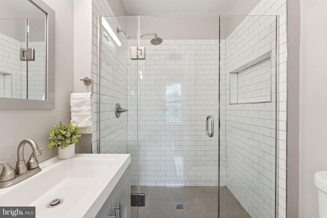a bathroom with a sink shower and a mirror