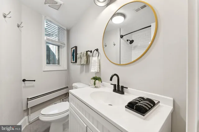 a bathroom with a sink a toilet and a mirror