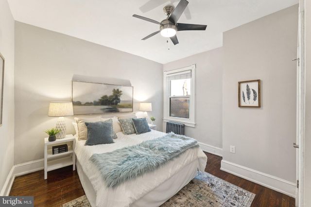 a bedroom with a bed a rug and wooden floor