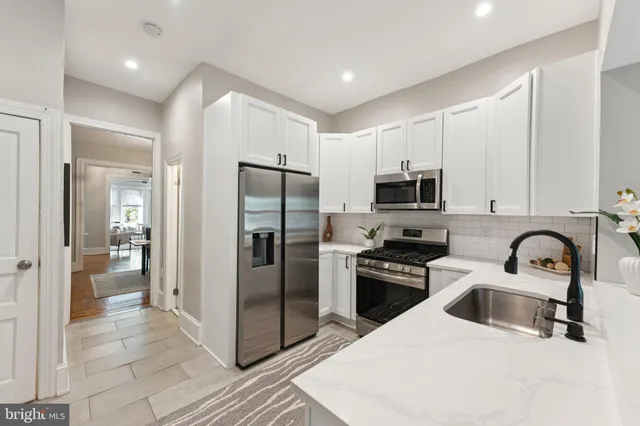 a kitchen with stainless steel appliances granite countertop a refrigerator and a sink