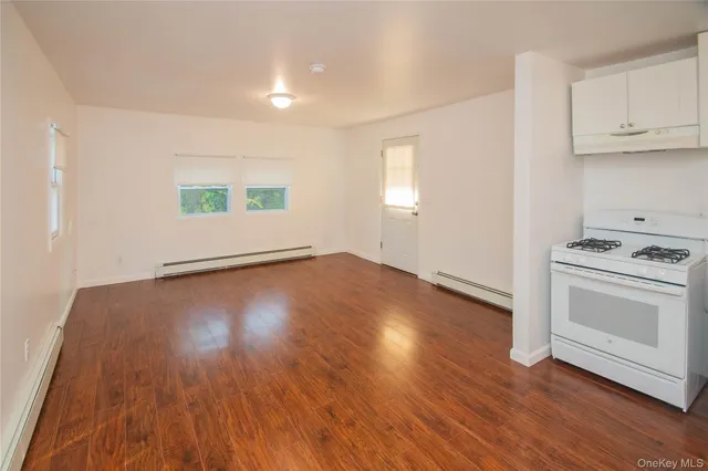 a view of a kitchen with wooden floor and a stove top oven