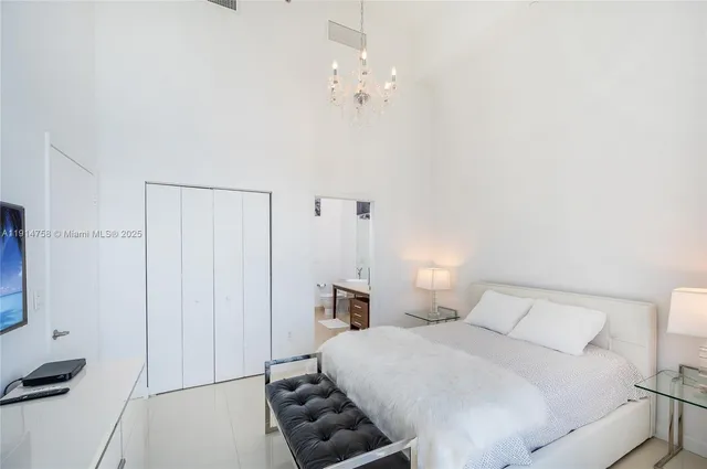 a bedroom with a bed and a chandelier