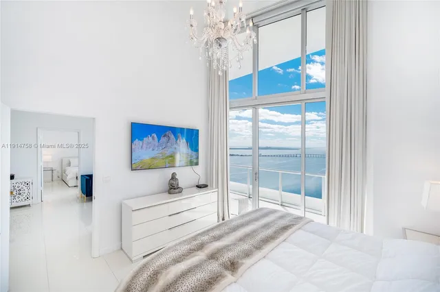 a spacious bedroom with a bed and a chandelier