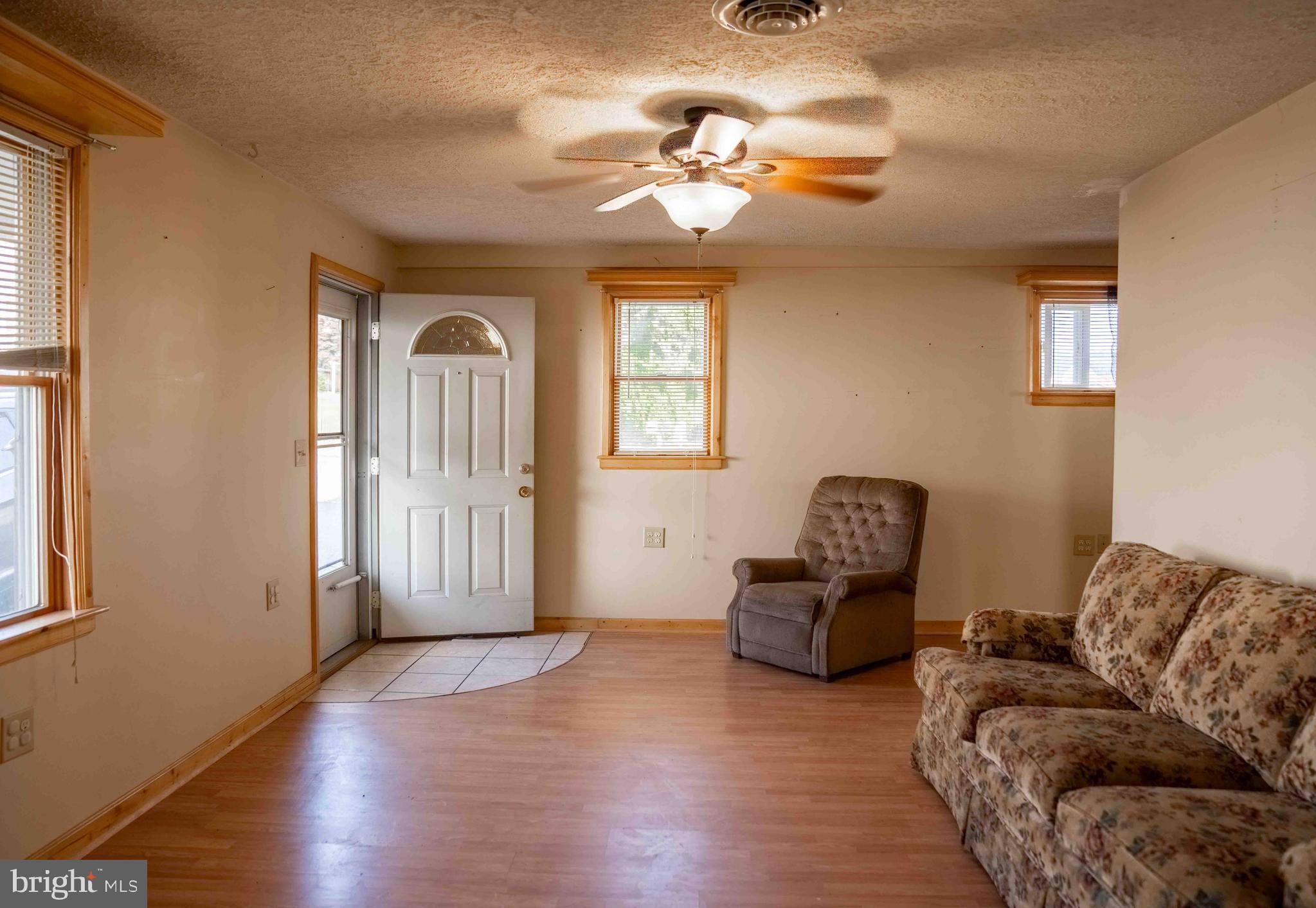 61 Maple Street Cumberland, MD 21502 - Photo 3 of 17 a living room with furniture and a large mirror next to a window
