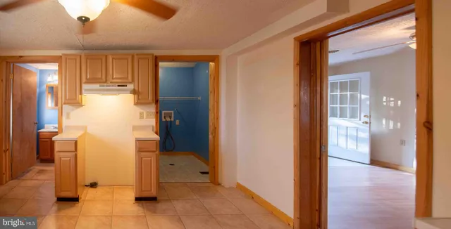 a view of a hallway with wooden floor and a bathroom