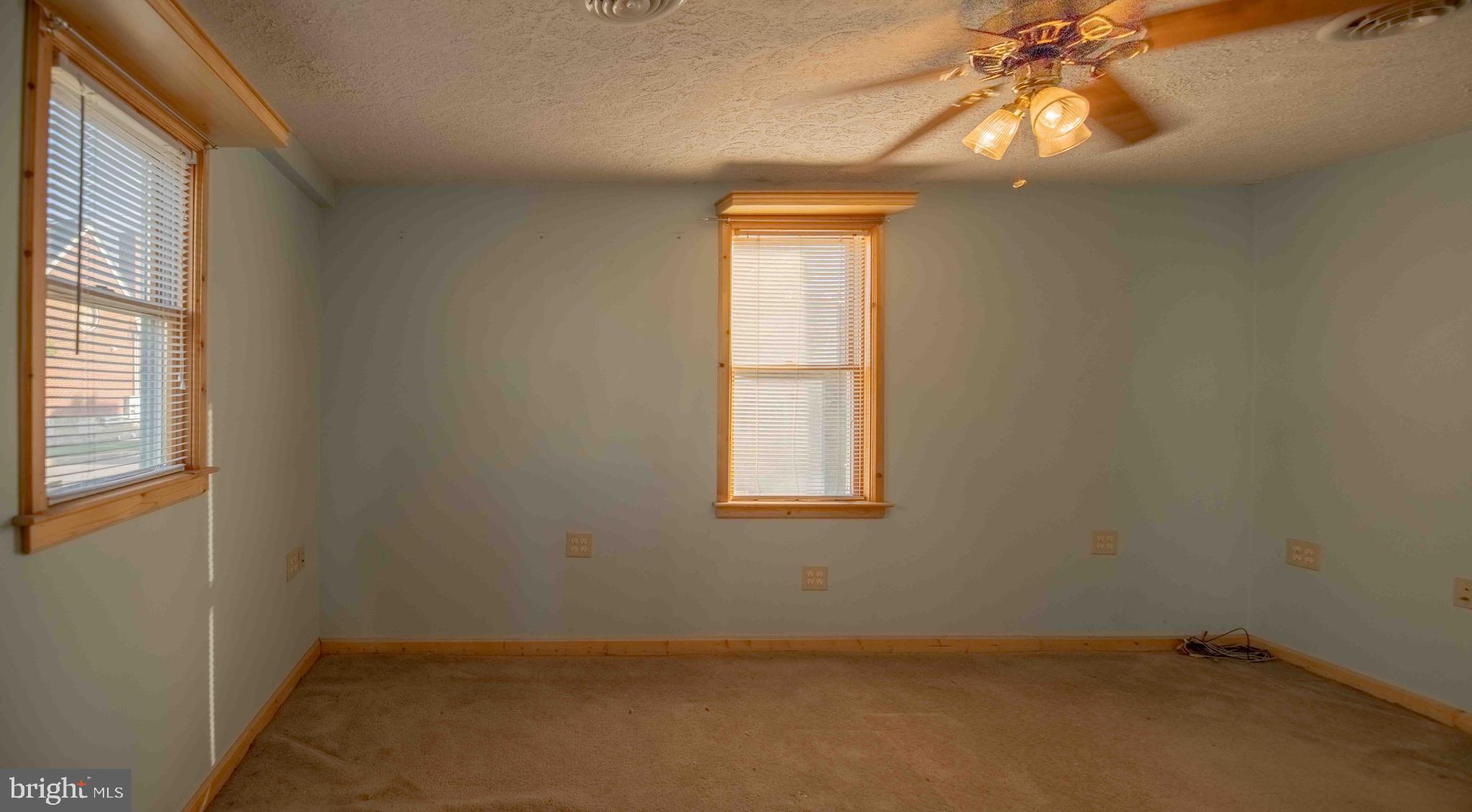 61 Maple Street Cumberland, MD 21502 - Photo 8 of 17 an empty room with a window and a chandelier fan
