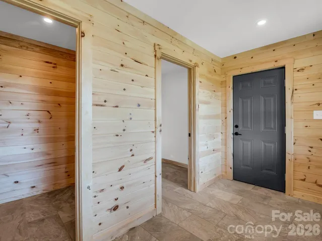walk in closet with white cabinet and shower