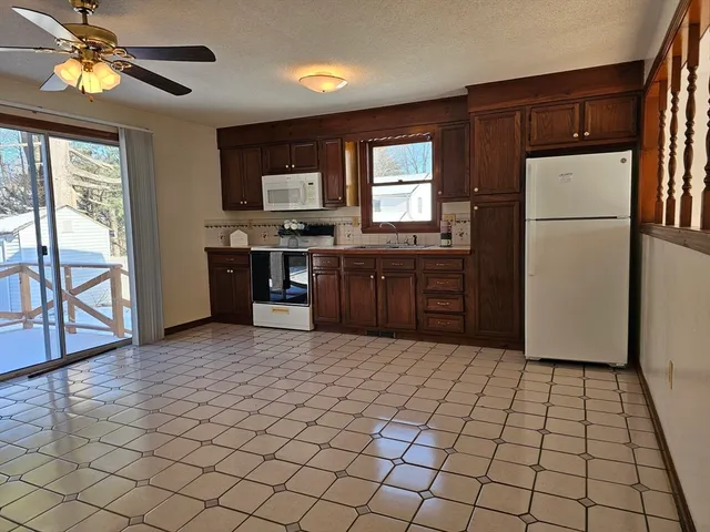 a view of a dining room with furniture a kitchen and chandelier