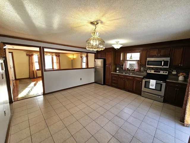 a large kitchen with granite countertop stainless steel appliances lots of counter space and window