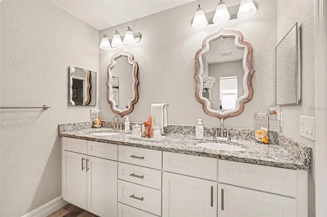a bathroom with double vanity sinks and a mirror